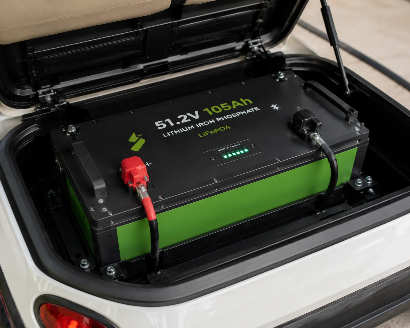 Lithium iron phosphate battery pack installed in golf cart bed with charge indicator lights visible.